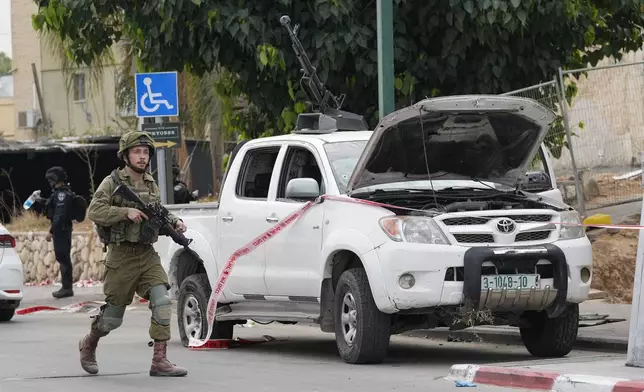 FILE - Israeli soldier walks by a pickup truck used by Palestinian militants in Sderot, Israel, on Saturday, Oct. 7, 2023. The Israeli military said Monday April 22, 2024 that the head of its intelligence corps has resigned over Hamas’ Oct. 7 attack. Aharon Haliwa, the head of Israel’s military intelligence, becomes the first senior Israeli figure to step down over the failures surrounding Hamas’ attack. (AP Photo/Ohad Zwigenberg, File)