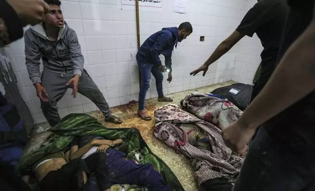 Bodies of people killed in the Israeli bombardment of the Gaza Strip are brought to al Aqsa Hospital in Deir al Balah, Gaza Strip, Tuesday, April 9, 2024. (AP Photo/Abdel Kareem Hana)