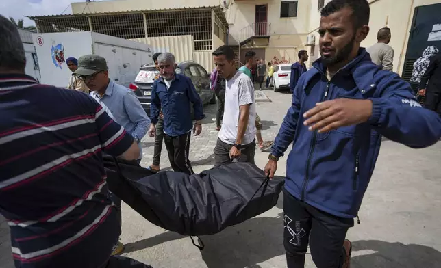 People carry the bodies of Palestinians who were killed in an Israeli airstrike in Nuseirat into the Al Aqsa hospital in Deir al Balah, Gaza Strip, Saturday, April 27, 2024. (AP Photo/Abdel Kareem Hana)