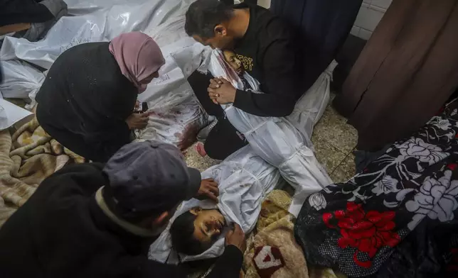 Palestinians mourn over the bodies of their relatives killed in the Israeli bombardment of the Gaza Strip at the morgue of Al Aqsa Hospital in Deir al Balah, Gaza Strip, Wednesday, April 10, 2024. (AP Photo/Ismael Abu Dayyah)