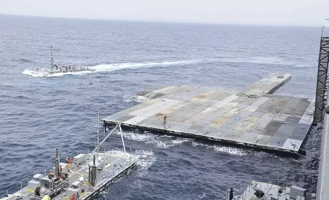 This undated photo released early Tuesday, April 30, 2024, by the U.S. military's Central Command shows construction off a floating pier in the Mediterranean Sea off the Gaza Strip. A U.S. Navy ship involved in the American-led effort to bring more aid into the besieged Gaza Strip is off shore from the enclave, slowly building out a floating platform for the operation, satellite photos analyzed Monday, April 29, 2024, by The Associated Press show. (U.S. military's Central Command via AP)