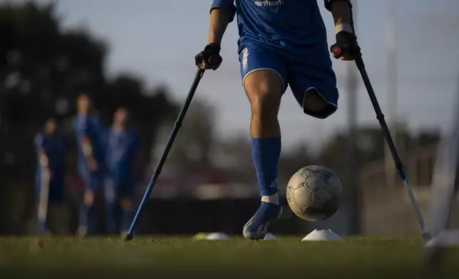 An Israel Amputee Football Team soccer player controls the ball during a practice session in Ramat Gan, Thursday, April 11, 2024. Amputee football stands out as a disability sport because the athletes aren't in wheelchairs. It is played with six outfield players who have lower extremity amputations and play with crutches and without prosthetics. (AP Photo/Leo Correa)