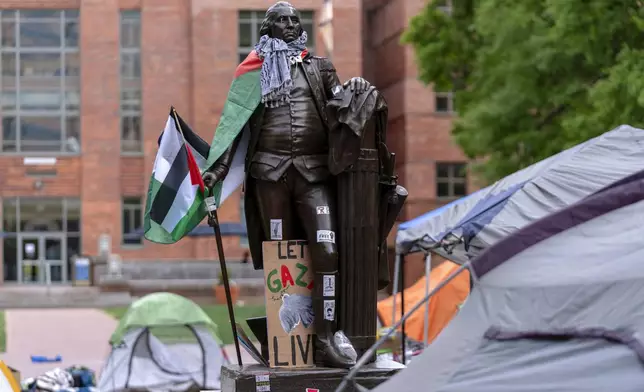 A statue of George Washington draped in a Palestinian flag and a keffiyeh is seen at George Washington University as students demonstrate on campus during a pro-Palestinian protest over the Israel-Hamas war on Friday, April 26, 2024, in Washington. (AP Photo/Jose Luis Magana)