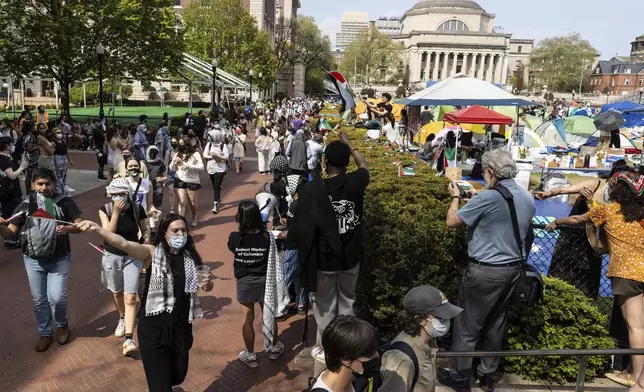 Student protesters march round their encampment on the Columbia University campus, Monday, April 29, 2024, in New York. (AP Photo/Stefan Jeremiah)