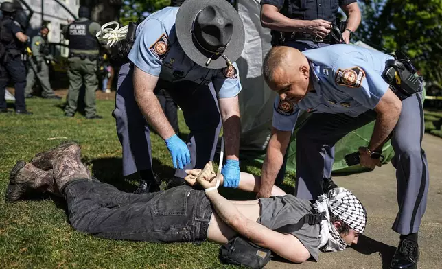 Georgia State Patrol officers detain a protester on the campus of Emory University during an pro-Palestinian demonstration Thursday, April 25, 2024, in Atlanta. (AP Photo/Mike Stewart)