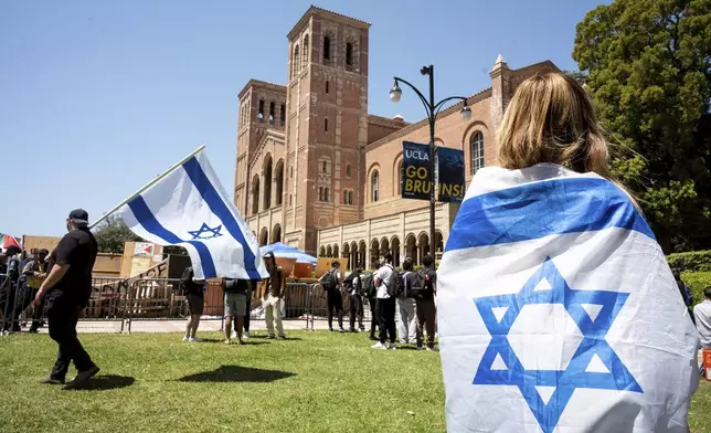 Israel supporters look on at a pro-Palestinian encampment in front of Royce Hall at UCLA, Monday, April 29, 2024. Pro-Palestinian supporters joined in a march from their encampment in front of Royce Hall to areas around the campus. (David Crane/The Orange County Register via AP)