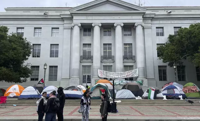 Pro-Palestinian protesters gather near an encampment set up in front of Sproul Hall on the campus of the University of California, Berkeley in Berkeley, Calif., Tuesday, April 23, 2024. The Israel-Hamas war protests creating friction at universities across the United States escalated Tuesday as some colleges encouraged students to attend classes remotely and dozens faced charges after setting up tents on campuses and ignoring official requests to leave. (AP Photo/Haven Daley)
