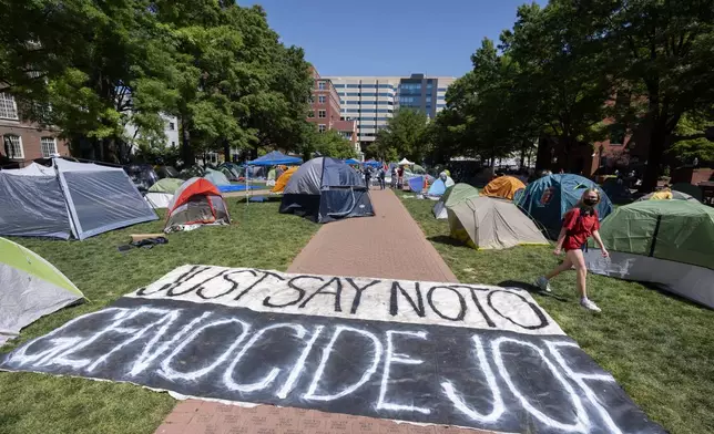 A banner reading "Just Say No To Genocide Joe" is unfurled on the ground at an encampment by students protesting against the Israel-Hamas war at George Washington University on Monday, April 29, 2024, in Washington. (AP Photo/Mark Schiefelbein)