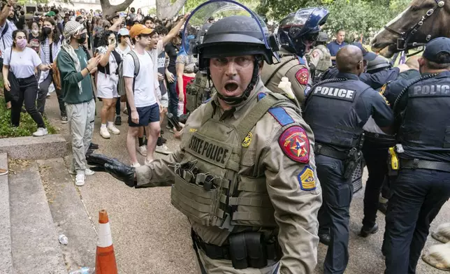 A state trooper yells for protesters to move back during a pro-Palestinian rally at the University of Texas Wednesday April 24, 2024 in Austin, Texas. Protests Wednesday on the campuses of at least two universities involved clashes with police, while another university shut down its campus for the rest of the week. (Mikala Compton/Austin American-Statesman via AP)