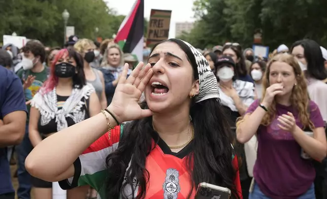 A pro-Palestinian protester, who declined to give her name, leads chants at the University of Texas, Wednesday, April 24, 2024, in Austin, Texas. (Jay Janner/Austin American-Statesman via AP)