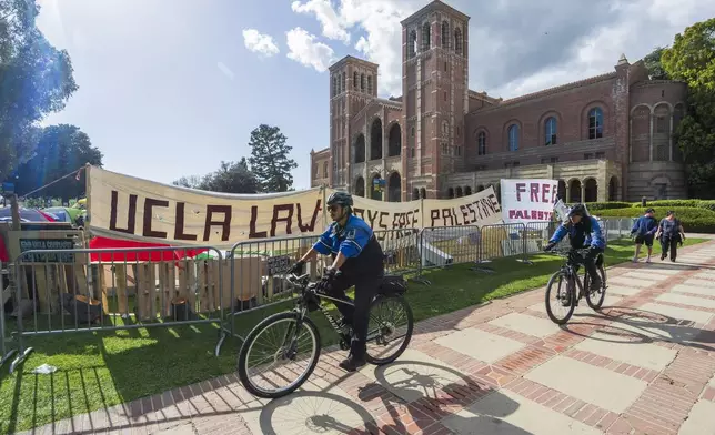 UCLA campus police cycle around the perimeter of a pro-Palestinian encampment on the UCLA campus Friday, April 26, 2024, in Los Angeles. As the death toll mounts in the war in Gaza and the humanitarian crisis worsens, protesters at universities across the country are demanding schools cut financial ties to Israel and divest from companies they say are enabling the conflict. (AP Photo/Damian Dovarganes)