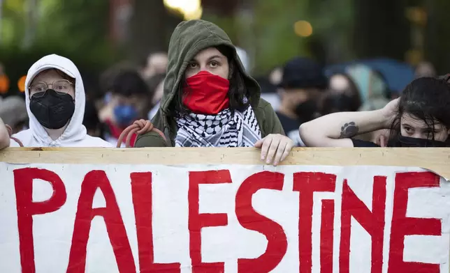 Demonstrators stand behind a sign in preparation for police to arrive during a pro-Palestinian rally at Virginia Commonwealth University, Monday, April 29, 2024, in Richmond, Va. (Mike Kropf/Richmond Times-Dispatch via AP)