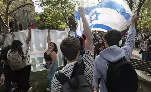 Penn junior Joe Hochberg (front middle) and sophomore Noah Rosen (right) hold up an Israeli flag during a pro-Palestinian protest on College Green in the heart of the University of Pennsylvania campus in Philadelphia on Thursday, April 25, 2024. (Elizabeth Robertson/The Philadelphia Inquirer via AP)