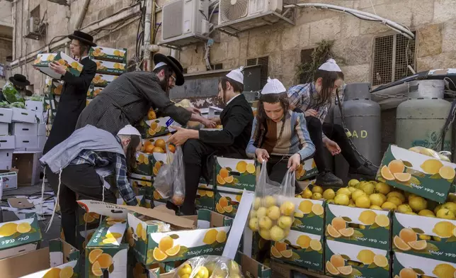 Ultra-Orthodox Jews collect food distributed to large families for free, in a special market ahead of the upcoming Passover holiday in Jerusalem, Thursday, April 18, 2024. Jews are forbidden to eat leavened foodstuffs during the Passover holiday that celebrates the biblical story of the Israelites' escape from slavery and exodus from Egypt. (AP Photo/Ohad Zwigenberg)