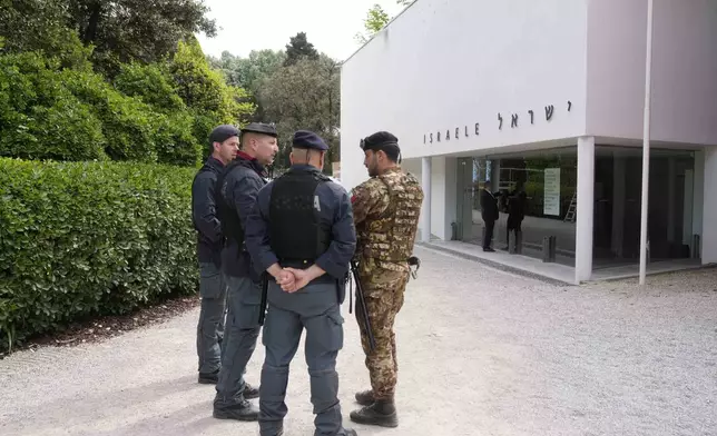 Italian police and an Italian soldier stand in front of the closed Israeli national pavilion at the Biennale contemporary art fair in Venice, Italy, Tuesday, April 16, 2024. The artist and curators representing Israel at this year's Venice Biennale have announced Tuesday they won't open the Israeli pavilion until there is a cease-fire in Gaza and an agreement to release hostages taken Oct. 7.(AP Photo/Luca Bruno)