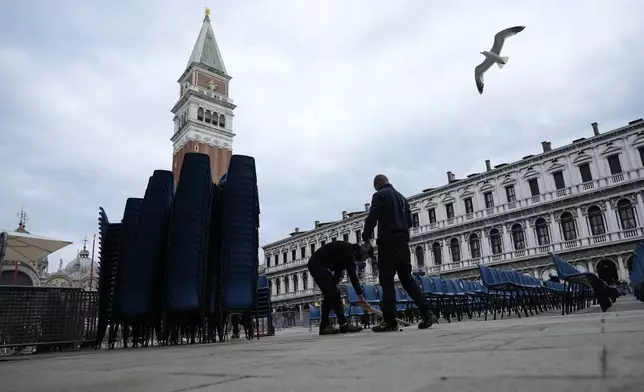 Workers put chairs in St. Mark Square on the occasion of the Pope Francis' visit in Venice, Italy, Saturday, April 27, 2024. Pope Francis will visit the lagoon city on Sunday, April 28. (AP Photo/Alessandra Tarantino)