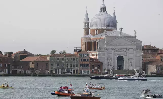 Pope Francis, foreground, is greeted by Gondoliers upon his arrival in Venice, Italy, Sunday, April 28, 2024. The Pontiff arrived for his first-ever visit to the lagoon town including the Vatican pavilion at the 60th Biennal of Arts. (AP Photo/Alessandra Tarantino)