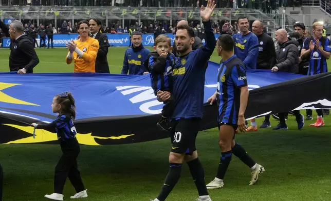Inter Milan's Hakan Calhanoglu waves with players celebrating in front of fans at the end of a Serie A soccer match between Inter Milan and Torino at the San Siro stadium in Milan, Italy, Sunday, April 28, 2024. Inter Milan had already clinched the Italian Serie A league title the week before. (AP Photo/Luca Bruno)
