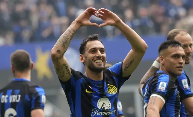 Inter Milan's Hakan Calhanoglu, centre, celebrates after scoring his side's second goal from a penalty kick during a Serie A soccer match between Inter Milan and Torino at the San Siro stadium in Milan, Italy, Sunday, April 28, 2024. (AP Photo/Luca Bruno)