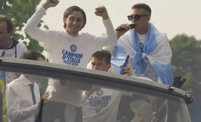 Inter Milan's Lautaro Martinez and his teammate Matteo Damian celebrate with teammates their 20th Italian Serie A top league title on a bus, in Milan, Italy, Sunday, April 28, 2024. (AP Photo/Luca Bruno)