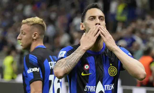 Inter Milan's Hakan Calhanoglu, right, celebrates after scoring his side's second goal during the Italian Serie A soccer match between Inter Milan and Cagliari at the San Siro stadium in Milan, Italy, Sunday, April 14, 2024. (AP Photo/Antonio Calanni)