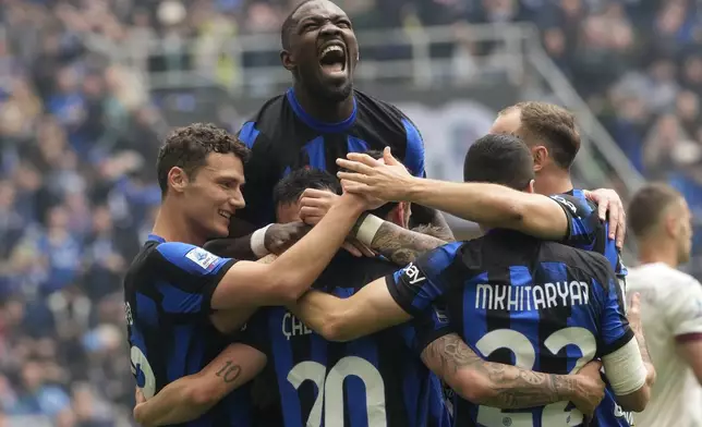 Inter Milan players celebrate after Hakan Calhanoglu, Bottom (number 20) scored his side's second goal from a penalty kick during a Serie A soccer match between Inter Milan and Torino at the San Siro stadium in Milan, Italy, Sunday, April 28, 2024. (AP Photo/Luca Bruno)