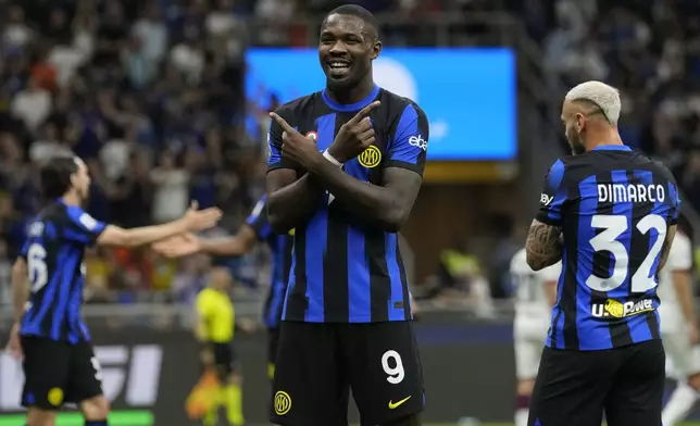 Inter Milan's Marcus Thuram, centre, celebrates after scoring his side's opening goal during the Italian Serie A soccer match between Inter Milan and Cagliari at the San Siro stadium in Milan, Italy, Sunday, April 14, 2024. (AP Photo/Antonio Calanni)