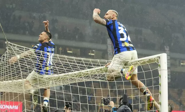 Inter Milan's Federico Dimarco, right, and Inter Milan's Lautaro Martinez celebrate at the end of the Serie A soccer match between AC Milan and Inter Milan at the San Siro stadium in Milan, Italy, Monday, April 22, 2024. (AP Photo/Luca Bruno)