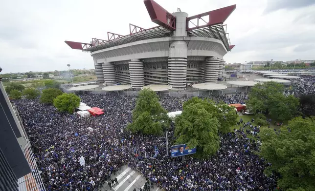 A crowd of fans wait outside the San Siro Stadium for the bus carrying the Inter Milan soccer team players celebrating their 20th Italian Serie A top league title, in Milan, Italy, Sunday, April 28, 2024. (AP Photo/Luca Bruno)