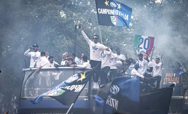 Inter Milan team is paraded in an open-air bus outside the San Siro stadium to the city cathedral to celebrate the Nerazzurri's 20th Italian league title, in Milan, Italy, Sunday, April 28, 2024. (Marco Ottico/LaPresse via AP)