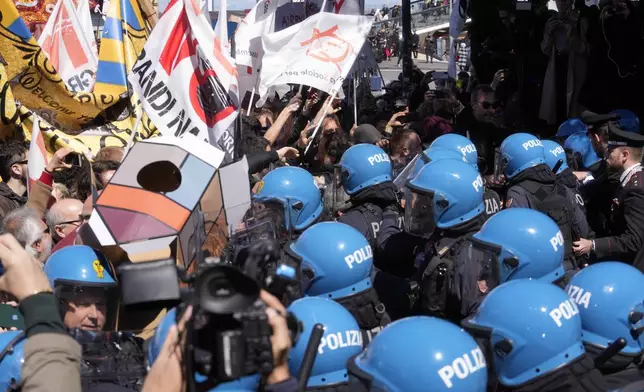 Citizens and activists confront police during a demonstration against Venice Tax Fee in Venice, Italy, Thursday, April 25, 2024. The fragile lagoon city of Venice begins a pilot program Thursday to charge daytrippers a 5 euro entry fee that authorities hope will discourage tourists from arriving on peak days. The daytripper tax is being tested on 29 days through July, mostly weekends and holidays starting with Italy's Liberation Day holiday Thursday. Officials expect some 10,000 people will pay the fee to access the city on the first day, downloading a QR code to prove their payment, while another 70,000 will receive exceptions, for example, because they work in Venice or live in the Veneto region. (AP Photo/Luca Bruno)