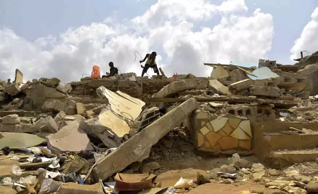People search through a demolished house in the Gesco neighborhood of Abidjan, Ivory Coast, Wednesday, Feb. 28, 2024. Rapid urbanisation has led to a population boom and housing shortages in Abidjan, where nearly one in five Ivorians reside, many of them in low-income, crowded communes like the ones in the Gesco and Sebroko districts being demolished on public health grounds. (AP Photo/Diomande Ble Blonde)
