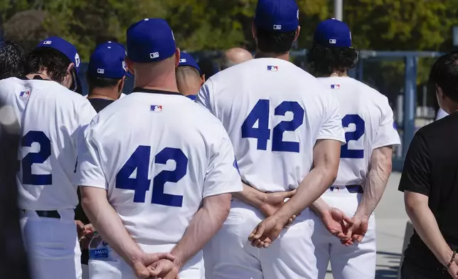 Los Angeles Dodgers pitchers Shohei Ohtani, center right, joins team members to celebrate Jackie Robinson Day before a baseball game against the Washington Nationals at Dodgers Stadium in Los Angeles on Monday, April 15, 2024. (AP Photo/Damian Dovarganes)