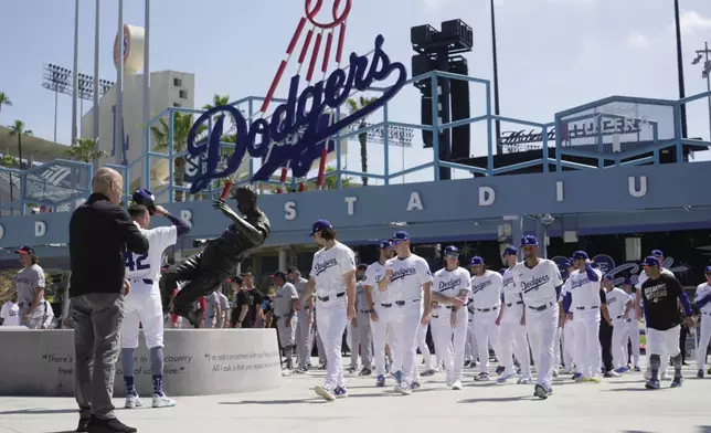 Los Angeles Dodgers and Washington Nationals team members arrive to celebrate Jackie Robinson Tribute Day before a baseball game at Dodgers Stadium in Los Angeles on Monday, April 15, 2024. (AP Photo/Damian Dovarganes)