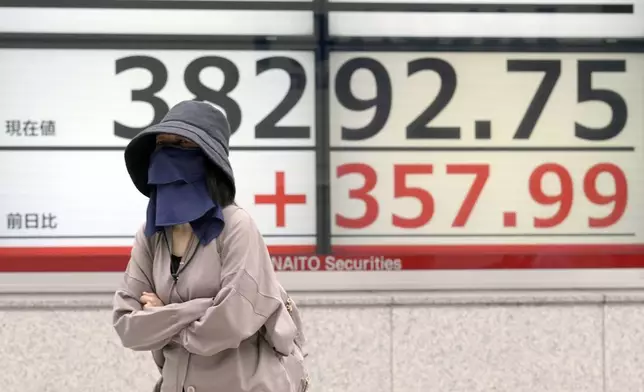 A person walks in front of an electronic stock board showing Japan's Nikkei 225 index at a securities firm Tuesday, April 30, 2024, in Tokyo. Asian shares mostly rose Tuesday, as investors kept their eyes on potentially market-moving reports expected later this week. (AP Photo/Eugene Hoshiko)