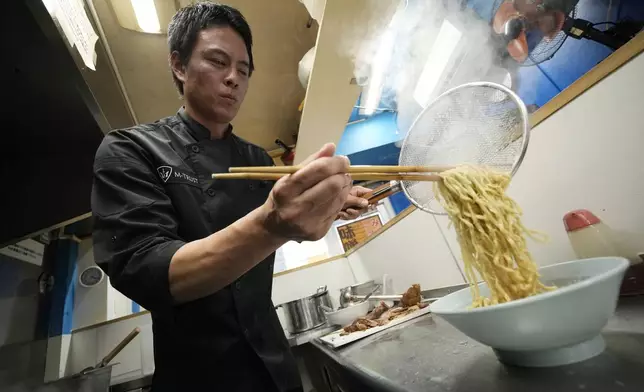 Kota Kobayashi prepares a bowl of noodle at his chain called "Ore No Ikiru Michi" in Tokyo on April 17, 2024. (AP Photo/Eugene Hoshiko)