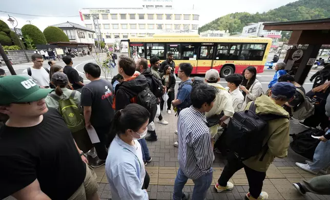 Tourists are packed at a train and bus station Tuesday, April 30, 2024, at Fujikawaguchiko town, Yamanashi Prefecture, central Japan. The town of Fujikawaguchiko, known for a number of popular photo spots for Japan's trademark of Mt. Fuji, on Tuesday began to set up a huge black screen on a stretch of sidewalk to block view of the mountain in a neighborhood hit by a latest case of overtourism in Japan. (AP Photo/Eugene Hoshiko)