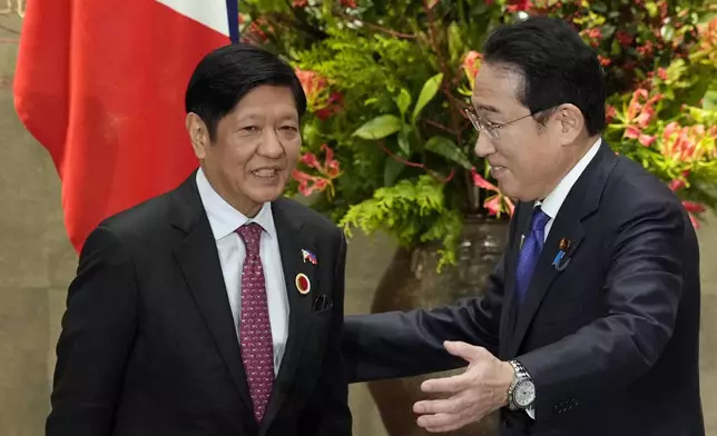 FILE - Japan's Prime Minister Fumio Kishida, right, greets Philippines' President Ferdinand Marcos Jr. prior to their bilateral meeting at the prime minister's official residence in Tokyo, Sunday, Dec. 17, 2023, on the sidelines of the Commemorative Summit for the 50th Year of ASEAN-Japan Friendship and Cooperation. The first-ever trilateral summit between President Joe Biden, Kishida and Philippine President Ferdinand Marcos Jr. comes as the Philippines faces escalating maritime tension with China over their contested South China Sea claims.(Franck Robichon/Pool Photo via AP, File)