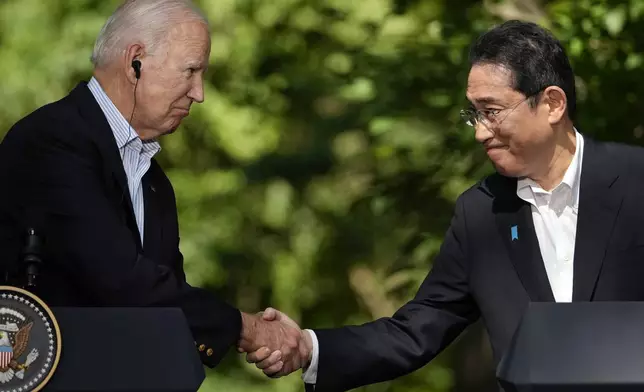 FILE - U.S. President Joe Biden, left, shakes hands with Japan's Prime Minister Fumio Kishida during a joint news conference with South Korean President Yoon Suk Yeol, not visible, on Aug. 18, 2023, at Camp David, the presidential retreat, near Thurmont, Md. Prime Minister Kishida is making an official visit to the United States this week. He will hold a summit with President Biden that's meant to achieve a major upgrading of their defense alliance.(AP Photo/Andrew Harnik, File)
