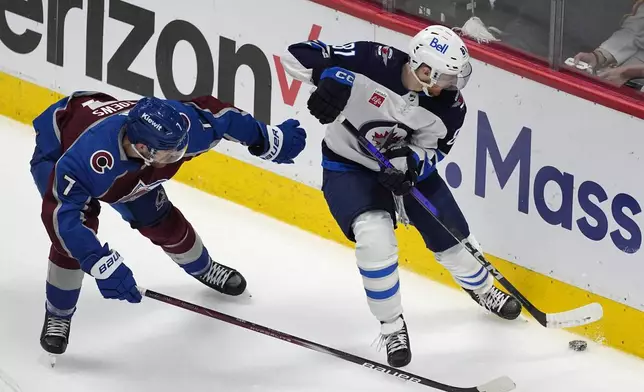 Winnipeg Jets left wing Kyle Connor, right, collects the puck as Colorado Avalanche defenseman Devon Toews covers in the third period of Game 4 of an NHL Stanley Cup first-round playoff series Sunday, April 28, 2024, in Denver. (AP Photo/David Zalubowski)