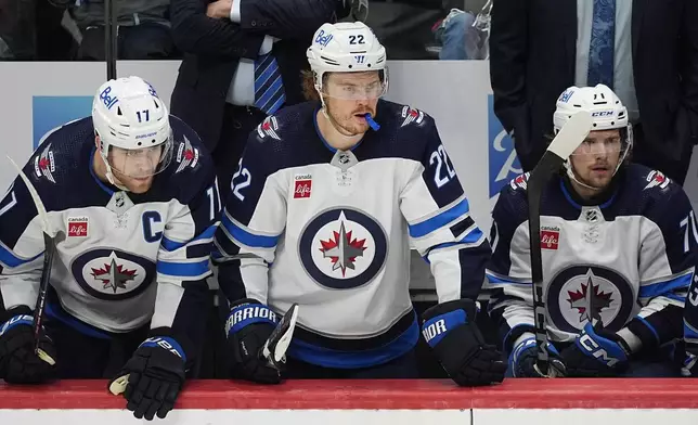 Winnipeg Jets center Adam Lowry, left, center Mason Appleton, center, and left wing Axel Jonsson-Fjallby, right, look on as time runs out in the third period of Game 4 of an NHL Stanley Cup first-round playoff series against the Colorado Avalanche, Sunday, April 28, 2024, in Denver. (AP Photo/David Zalubowski)