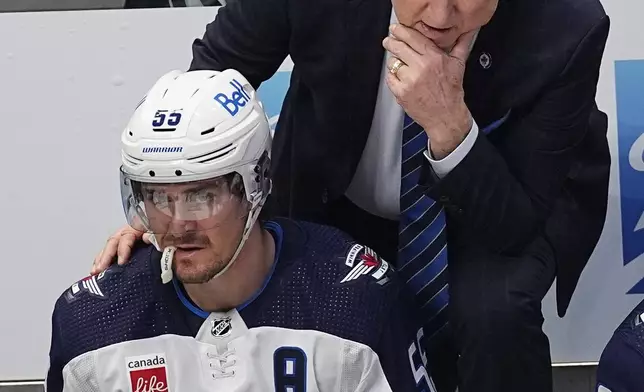 Winnipeg Jets hesd coach Rick Bowness, top, confers with center Mark Scheifele (55) in the third period of Game 4 of an NHL Stanley Cup first-round playoff series against the Colorado Avalanche, Sunday, April 28, 2024, in Denver. (AP Photo/David Zalubowski)