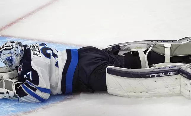 Winnipeg Jets goaltender Connor Hellebuyck remains on the ice after giving up a goal to Colorado Avalanche left wing Artturi Lehkonen during the third period of Game 3 of an NHL hockey Stanley Cup first-round playoff series Friday, April 26, 2024, in Denver. (AP Photo/David Zalubowski)