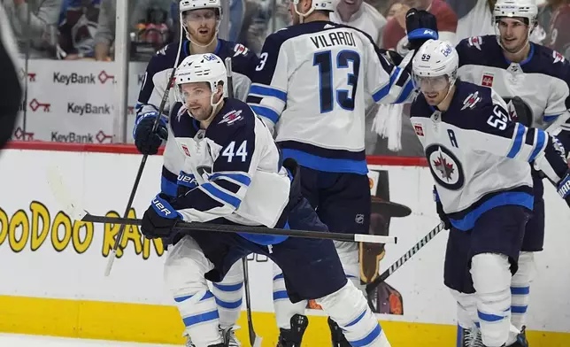 Winnipeg Jets defenseman Josh Morrissey heads to the team box after celebrating with teammates following his goal against the Colorado Avalanche during the second period of Game 3 of an NHL hockey Stanley Cup first-round playoff series Friday, April 26, 2024, in Denver. (AP Photo/David Zalubowski)