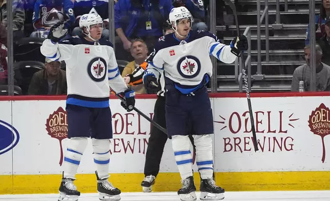 Winnipeg Jets center Sean Monahan, right, celebrates with center Tyler Toffoli after scoring in the first period of an NHL hockey game against the Colorado Avalanche, Saturday, April 13, 2024, in Denver. (AP Photo/David Zalubowski)