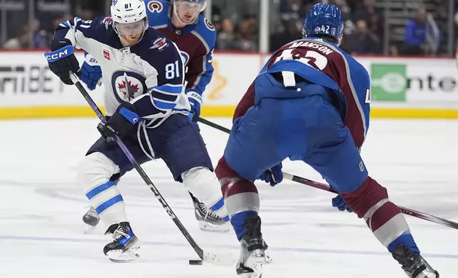 Winnipeg Jets left wing Kyle Connor, front left, collects the puck between Colorado Avalanche center Casey Mittelstadt, back left, and defenseman Josh Manson, right, in the second period of Game 4 of an NHL Stanley Cup first-round playoff series Sunday, April 28, 2024, in Denver. (AP Photo/David Zalubowski)