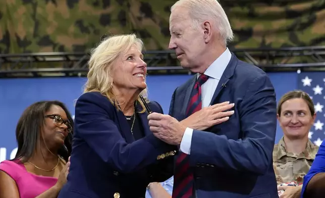 FILE - First lady Jill Biden looks at President Joe Biden as he holds the pen he used to sign an executive order aimed to bolster job opportunities for military and veteran spouses during a visit to Fort Liberty, N.C., June 9, 2023. President Joe Biden's administration has announced new steps to improve a program that lets federal employees who also are military spouses telework from overseas. The steps are part of Jill Biden's work to support military and veteran families. (AP Photo/Susan Walsh, file)