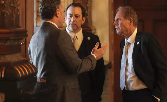 Kansas Senate President Ty Masterson, R-Andover, confers with House Appropriations Committee Chair Troy Waymaster, R-Bunker Hill, and Senate Ways and Means Committee Chair Rick Billinger, R-Goodland, right, during the Senate's session, Wednesday, March 27, 2024, at the Statehouse in Topeka, Kan. Waymaster and Billinger are the lead negotiators for their chambers as they settle their differences on a proposed $25 billion state budget. (AP Photo/John Hanna)