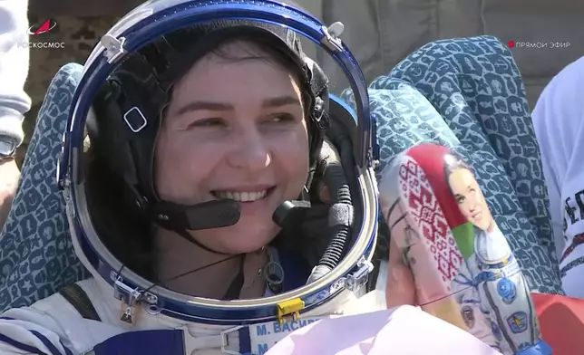 In this grab taken from video released by the Roscosmos Space Corporation Marina Vasilevskaya of Belarus sits in a chair and holds a Matryoshka, Russian traditional wooden dolls depicting her shortly after the landing of the Russian Soyuz MS-24 space capsule, near Zhezkazgan, Kazakhstan, Saturday, April 6, 2024. The Soyuz capsule carrying NASA astronaut Loral O'Hara, Oleg Novitsky of Roscosmos and Marina Vasilevskaya of Belarus touched down on Saturday. (Roscosmos space corporation via AP)