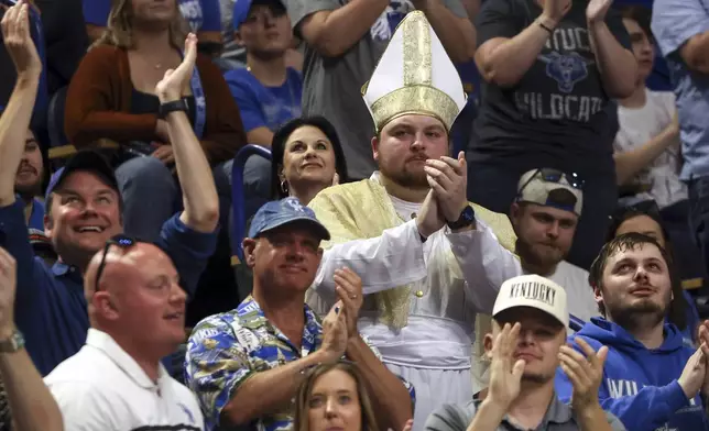 A fan dressed as the pope listens as Mark Pope speak to fans and the media after being named Kentucky men's NCAA college basketball head coach in Lexington, Ky., Sunday, April 14, 2024. (AP Photo/James Crisp)